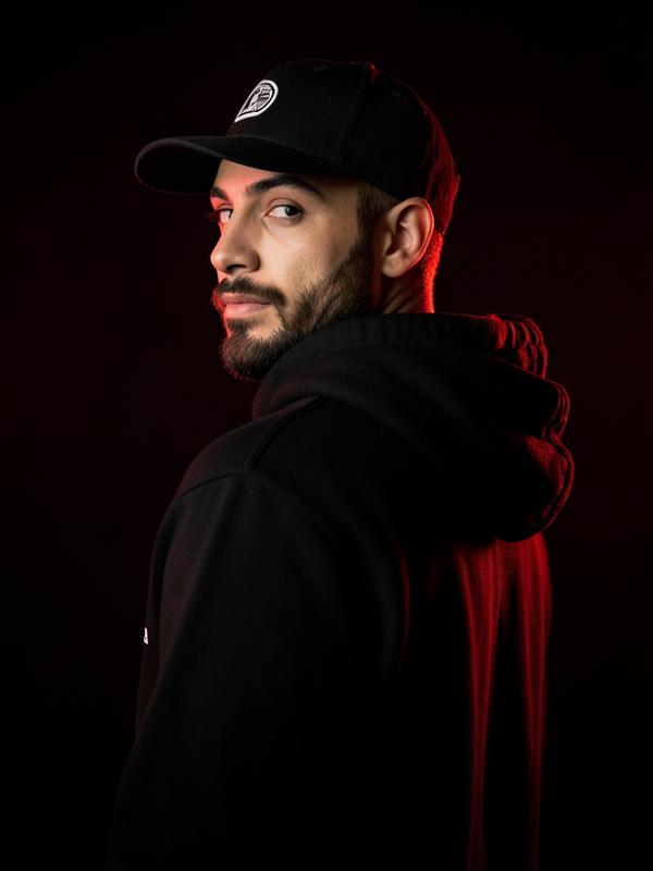 BUBU35 in a black hoodie and cap under red studio lighting